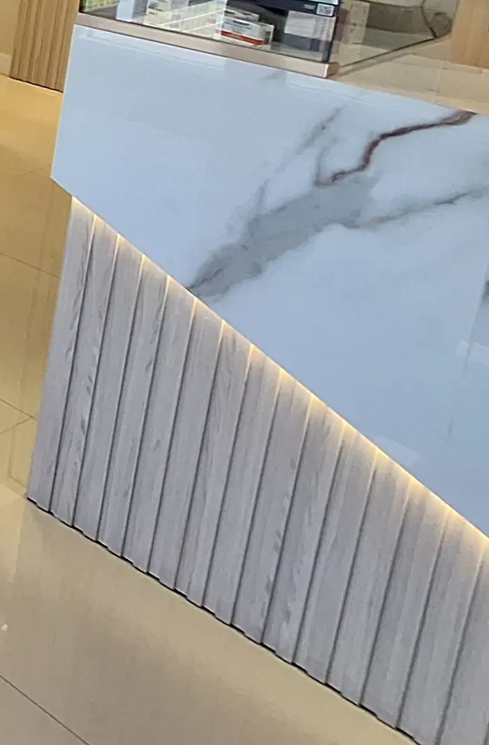 Balcão de mármore com ripado de madeira e luz indireta
